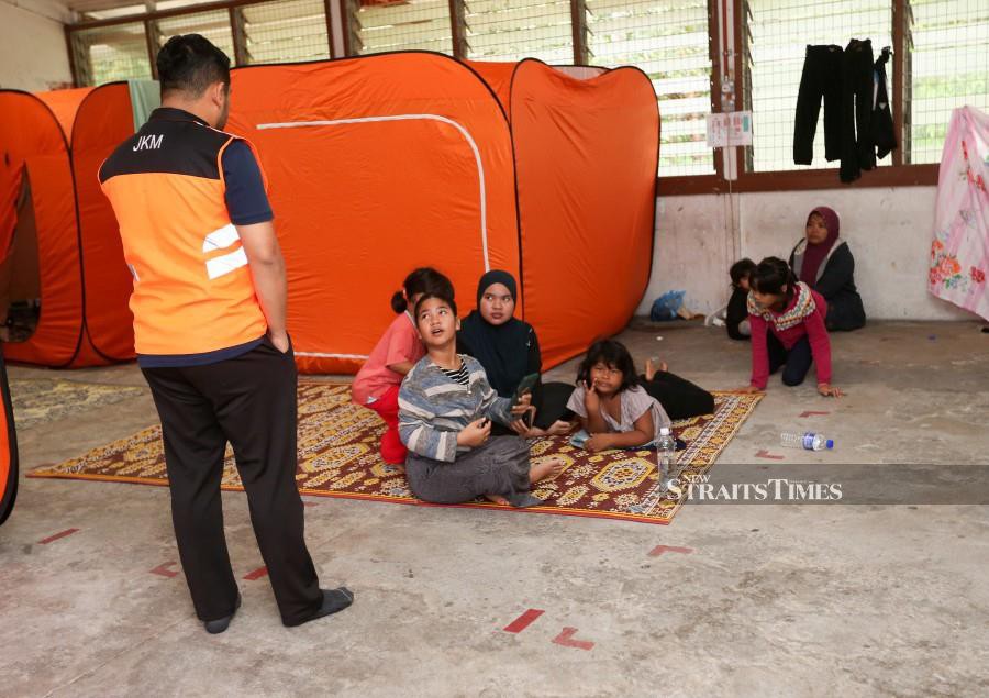 A Welfare Department personnel checking on the wellbeing of evacuees at a relief centre in Sekolah Kebangsaan Wakaf Raja, Pasir Puteh. -NSTP/NIK ABDULLAH NIK OMAR