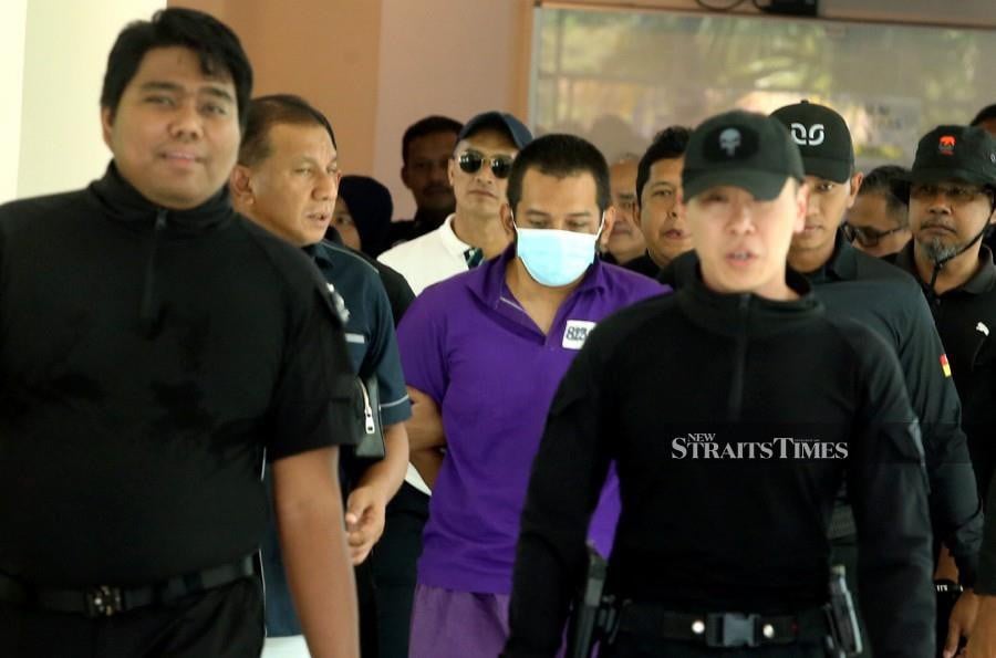 Hafizul Hawari (centre) is escorted by police officers after arriving at the Police Air Operation Force (PGU) base in Subang Jaya. - NSTP/HAIRUL ANUAR RAHIM