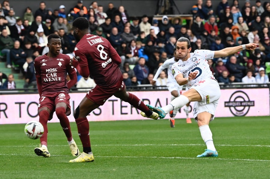 Lille's Yusuf Yazici (R) takes a shot in front of Metz's Ismael Traore (C) and Danley Jean Jacques (L) during the match at the Saint-Symphorien stadium in Longeville-les-Metz, eastern France. - AFP PIC