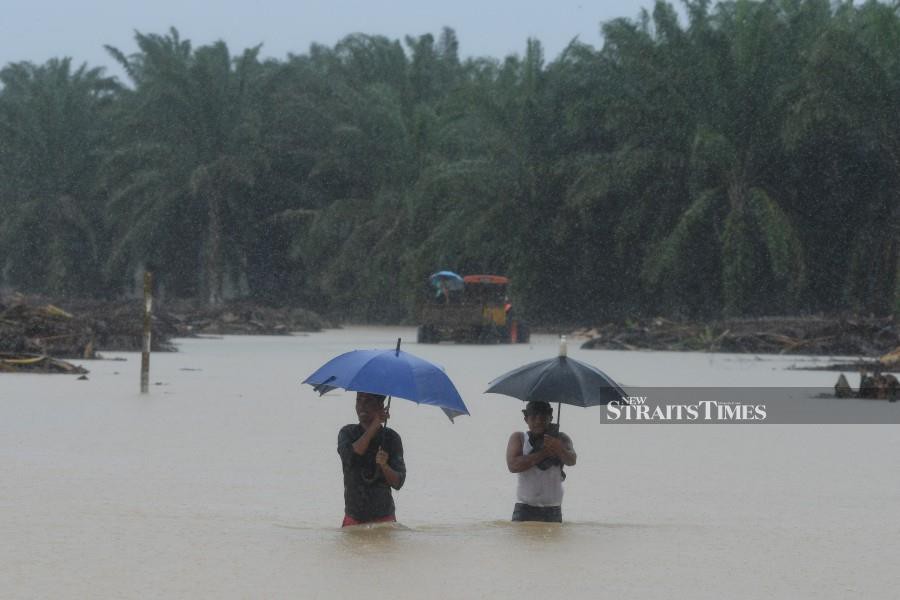 Residents brave through the floods waters in Kampung Padang Kubu, Kemaman. - BERNAMA PIC