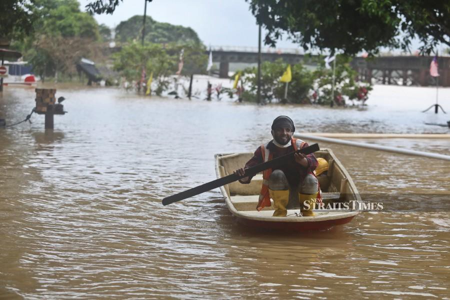 A man uses a sampan to travel during the floods in Kuala Terengganu. -NSTP/GHAZALI KORI