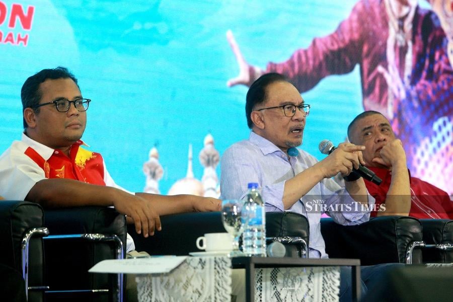Prime Minister Datuk Seri Anwar Ibrahim (centre) speaks during the Central Zone Madani Rakyat Programme in Kuala Selangor. Also present are are Selangor Menteri Besar Datuk Seri Amirudin Shari (left) abd Perak Menteri Besar Datuk Seri Saarani Mohamad (right). -NSTP/FAIZ ANUAR