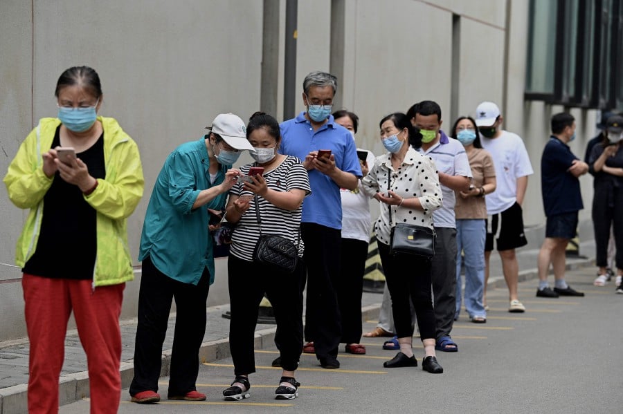 People queue to be tested for the Covid-19 coronavirus at a swab collection site in Beijing. - APF PIC