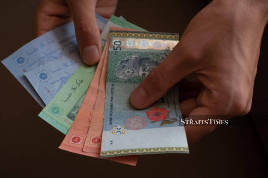 Man counts holding Malaysia Ringgit