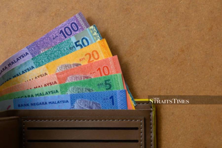 Image of men's purse with Malaysian Currency Ringgit note on the wooden table.