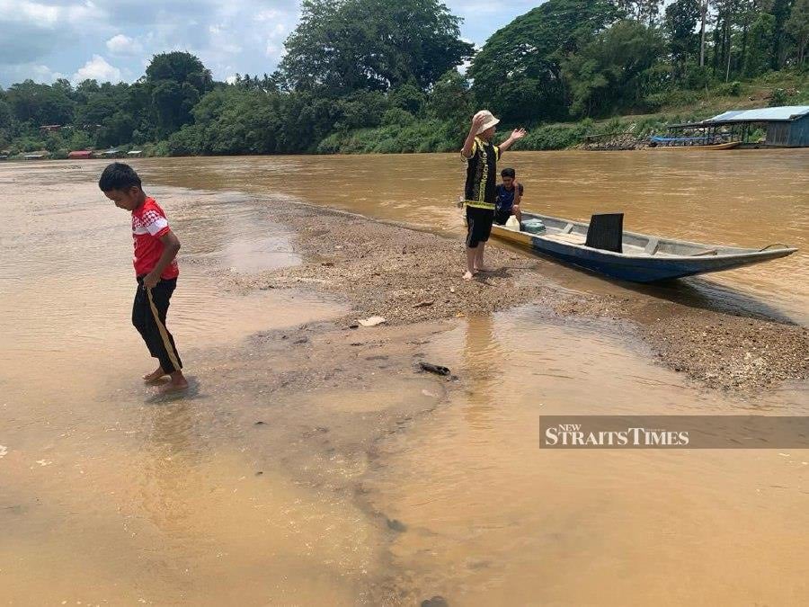 Children seen playing in the river after it dried up due to the hot weather at Krai Steps. - NSTP/Sharifah Mahsinah Abdullah