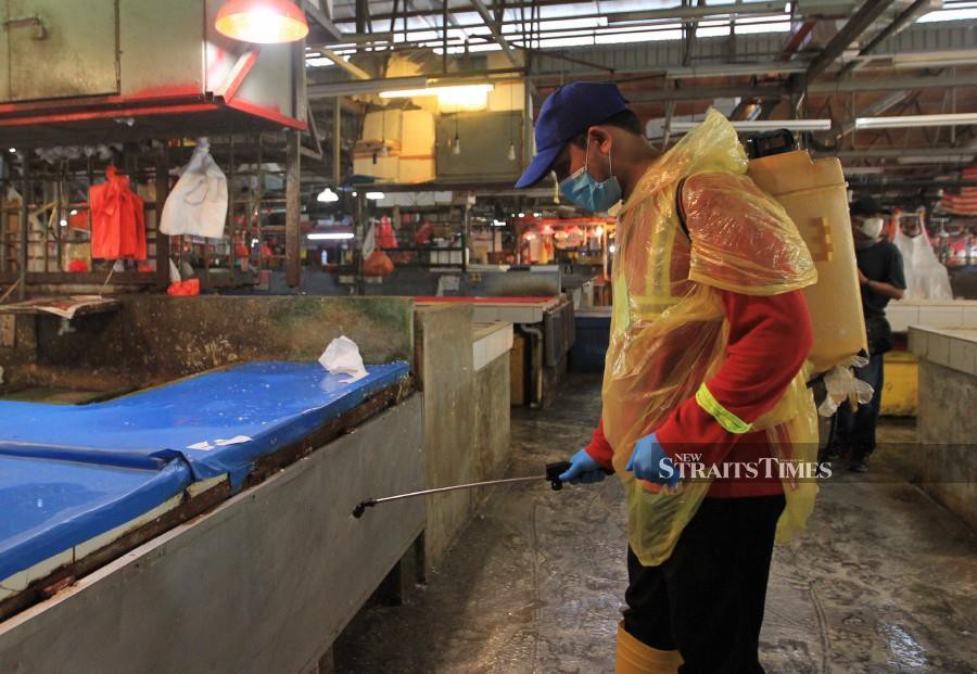 An employee of Alam Flora conducts sanitisation process at Pasar Jalan Raja Bot. -NSTP/FATHIL ASRI.