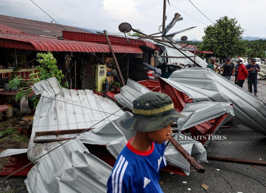 Residents of Taman Klebang Jaya inspecting the damage caused by the storm. - BERNAMA PIC