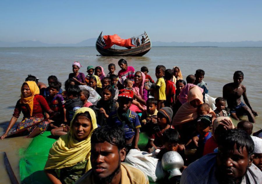 Rohingya refugees sit on a makeshift boat as they get interrogated by the Border Guard Bangladesh after crossing the Bangladesh-Myanmar border, at Shah Porir Dwip near Cox’s Bazar, Bangladesh. -REUTERS file pic