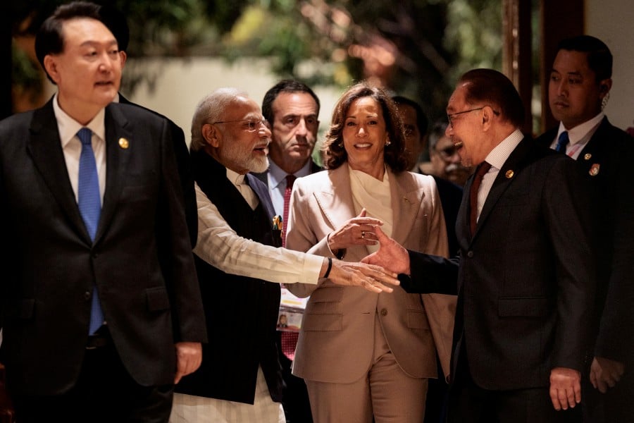 India’s Prime Minister Narendra Modi (2nd L) and Prime Minister Datuk Seri Anwar Ibrahim (2nd R) shake hands as they enter with US Vice President Kamala Harris (C) to attend the 18th East Asia Summit during the 43rd Asean Summit in Jakarta, Indonesia. - REUTERS PIC