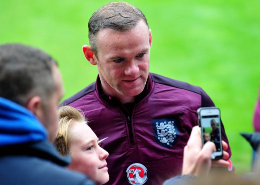 England 's Wayne Rooney poses for pictures with fans during a training session at St George's Park near Burton-on-Trent, central England, ahead of England's Euro 2016 game against Slovenia at London's Wembley Stadium. AFP PHOTO.