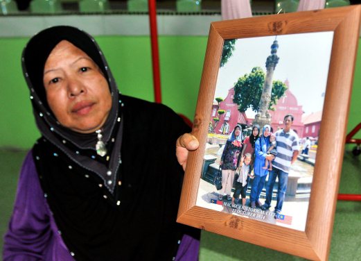 The mother of a woman found dead in a bushy area under a flyover bridge in Cyberjaya identified as 30-year-old Rosshida Abdullah from Pasir Mas, Kelantan, is showing a picture of the family. Pix by Nik Abdullah Nik Omar