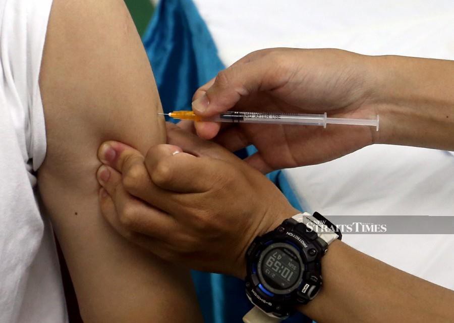 A medical officer administers a Covid-19 booster shot at Dewan Ang Si Chong vaccination centre in Butterworth, Penang on February 13. -NSTP/DANIAL SAAD