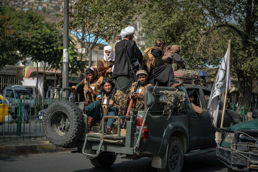 Taliban fighters patrol along a street in Kabul. - AFP PIC
