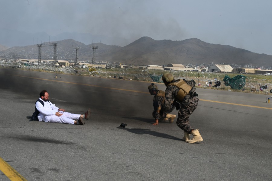 Taliban Badri special force fighters (R) and a journalist get up after they fell down from a vehicle at the airport in Kabul. - AFP PIC