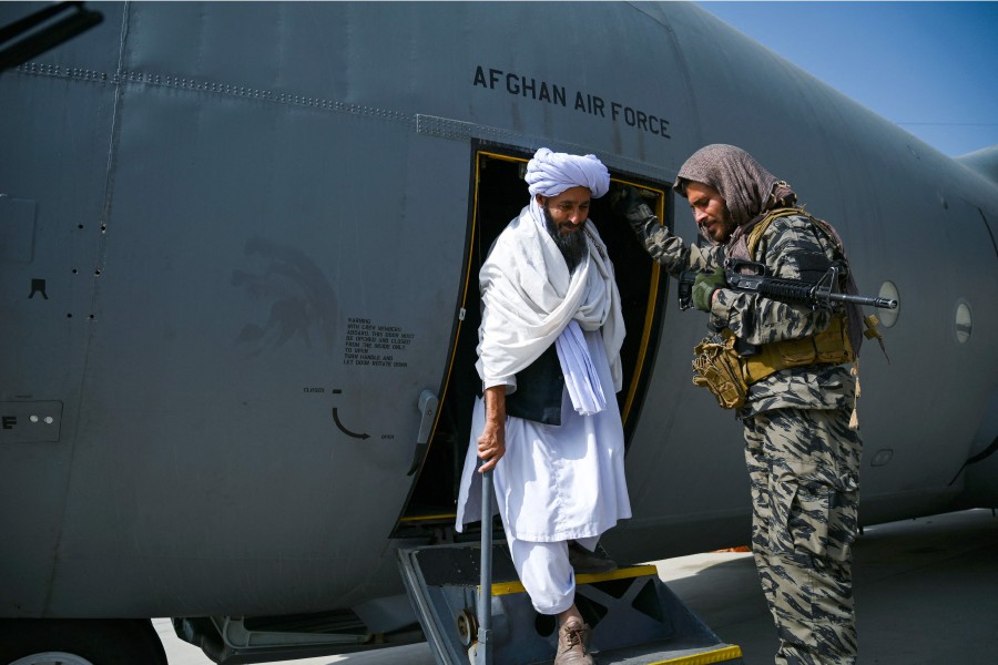 A member of the Taliban (C) walks out of an Afghan Air Force aircraft at the airport in Kabu. - AFP PIC