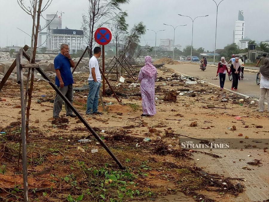 The road along Pantai Maimi is covered in dirt and rubbish following the high tide. -NSTP/BAHAROM BAKAR.