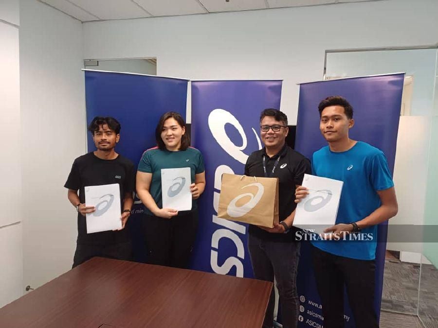 (From left) Marathon runner Haziq Hamzah, women’s discus thrower Queenie Ting, ASICS country manager Boon Tib Soom Nik and 400m runner Umar Osman after the signing ceremony yesterday.
