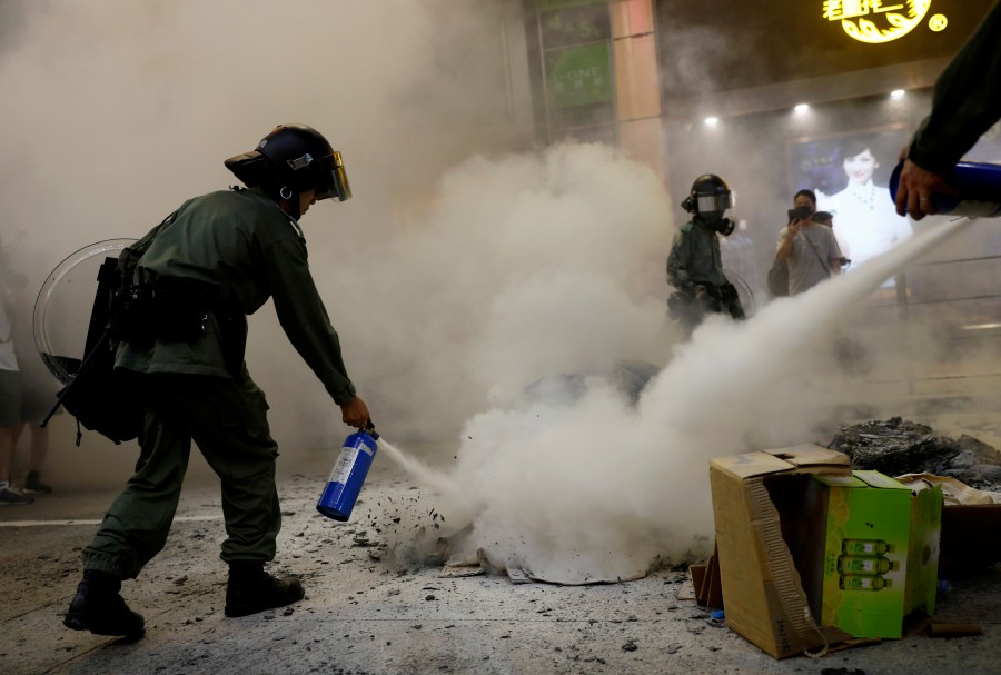 Riot police use fire extinguishers during a demonstration in Mong Kok district in Hong Kong. - Reuters