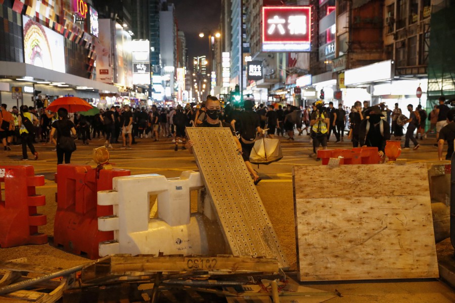  A protester sets up barricades during a rally against police's violence at Mong Kok, in Hong Kong. - EPA
