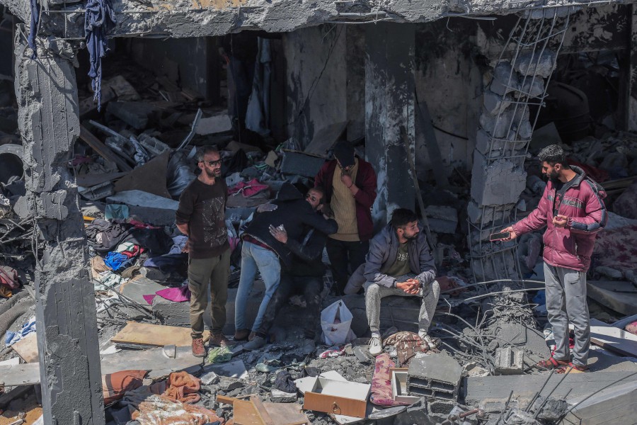 Palestinians sit on the rubble of a destroyed house following overnight Israeli bombardment which hit the al-Habash family home at the Nuseirat refugee camp in the central Gaza Strip. - AFP PIC