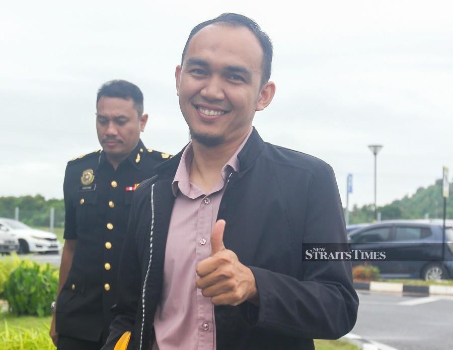 Syafeeq Mohd Shukri, son of Perlis Menteri Besar Mohd Shukri Ramli, gestures as he arrives at the Kangar Court ahead of his trial. -NSTP/WAN NABIL NASIR.