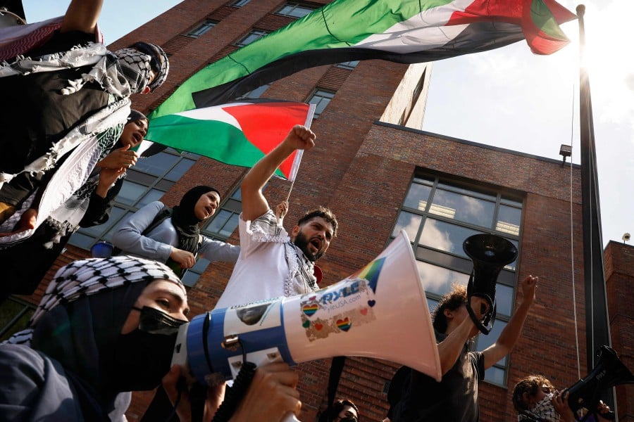Pro-Palestinian demonstrators use a large Palestinian flag to block the doors to Bell Hall as they rally on the campus of George Washington University in Washington, DC. - AFP PIC
