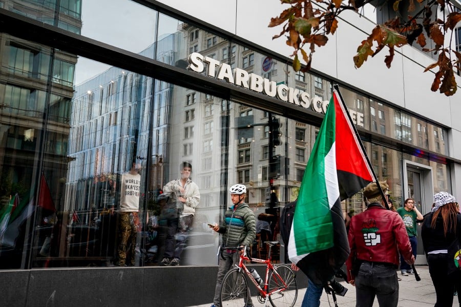 People watch from inside a Starbucks as demonstrators march in support of Palestinians in Gaza, amid the ongoing conflict between Israel and Hamas, in Washington, U.S. (REUTERS/Elizabeth Frantz)