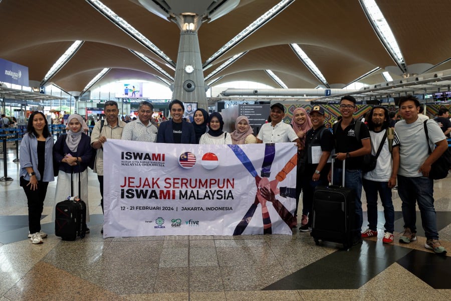 Ikatan Setiakawan Malaysia-Indonesia (Iswami) Malaysia president Ashwad Ismail (centre) with journalists pose for a picture before departing to Indonesia at the Kuala Lumpur International Airport. - BERNAMA PIC