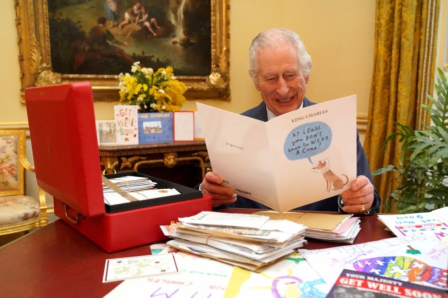 FILE PHOTO: Britain's King Charles reads cards and messages, sent by well-wishers following his cancer diagnosis, in the 18th Century Room of the Belgian Suite in Buckingham Palace, London, Britain on Feb 21. -- Jonathan Brady/Pool via REUTERS/File Photo
