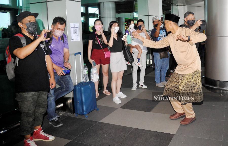 Cultural dancers performing while welcoming the passengers at the Kota Kinabalu International Airport. - NSTP/MOHD ADAM ARININ