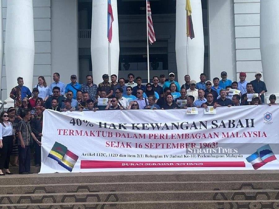Supporters holding a banner ahead of the hearing at the Kota Kinabalu High Court. -NSTP/ Ersie Anjumin