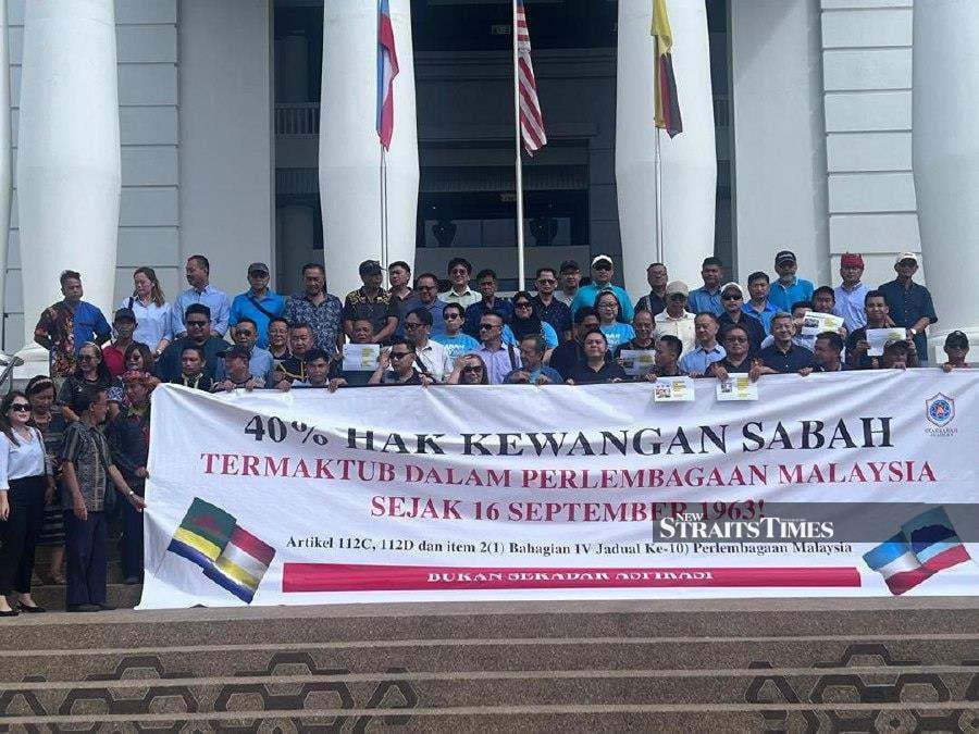 Supporters holding a banner ahead of the hearing at the Kota Kinabalu High Court last month. - NSTP/ Ersie Anjumin