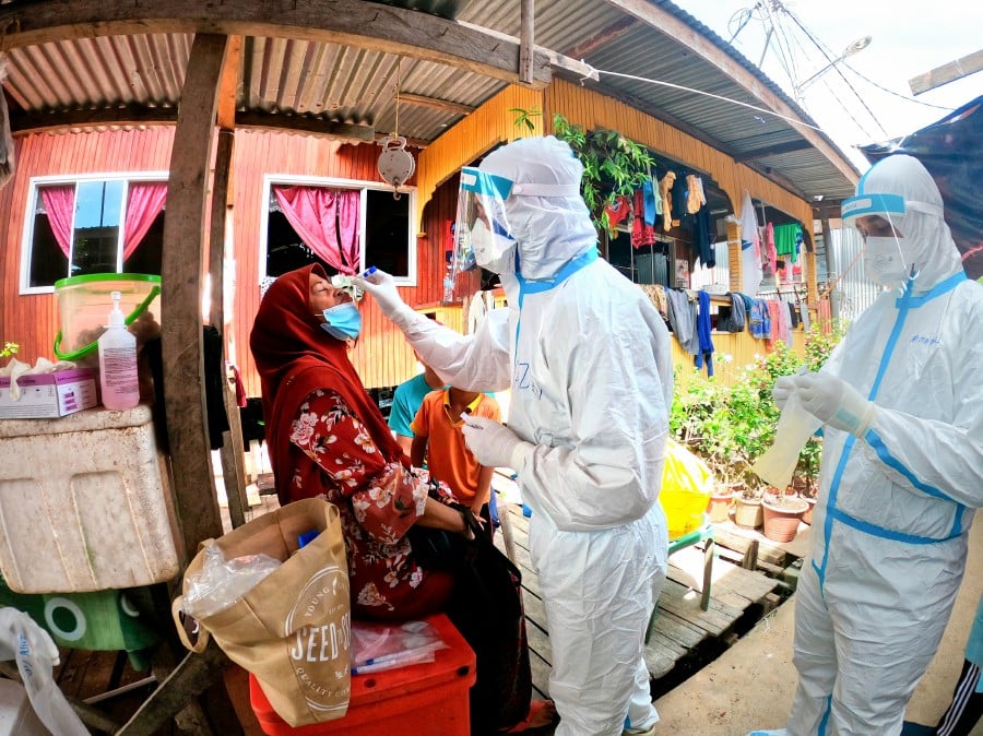 Health Ministry personnel conduct Covid-19 tests on residents of Kampung Lupak Meluas Darat in Sabah, today. Bernama pic