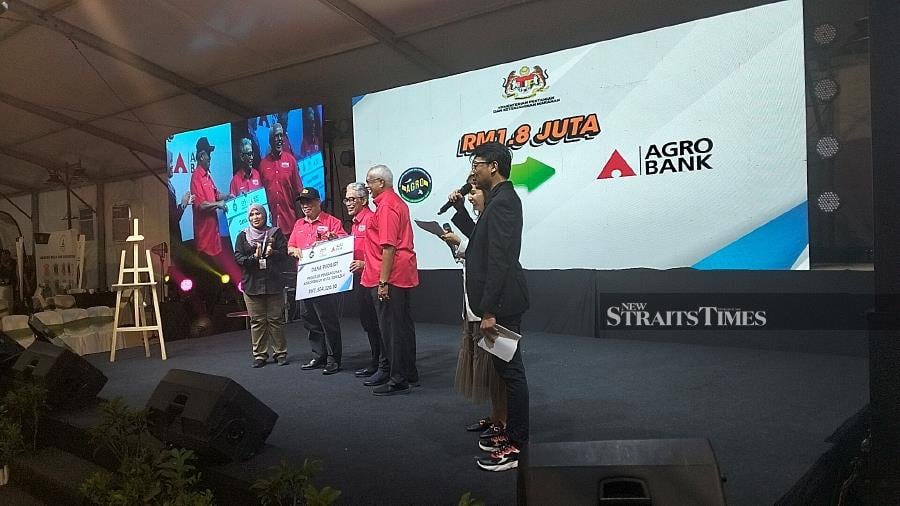 Agriculture and Food Security Minister Datuk Seri Mohamad Sabu (left) handing over a mock cheque to AGROBANK chief executive officer Datuk Tengku Ahmad Badli Shah Raja Hussin, during the launch of the Young Agropreneur Graduate Programme in conjunction with the 2023 National Farmers, Breeders and Fishermen's Day (HPPNK) at Bulatan Sultan Azlan Shah. -NSTP/MUHAMMAD ZULSYAMINI SUFIAN SURI