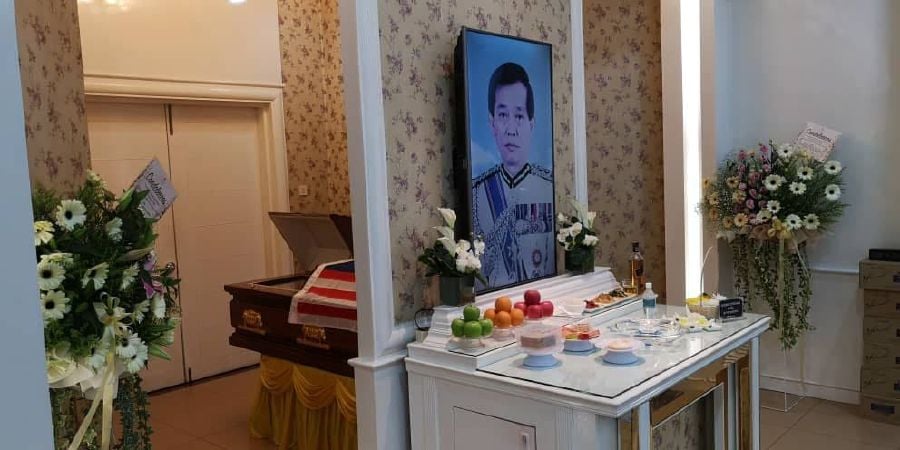 The late retired Senior Assistant Commissioner 1 Datuk Leong Chee Woh's remains lie in a Jalur Gemilang-draped coffin at the back of an altar with his portrait, at his funeral at the Nirvana Memorial Centre in Sungai Besi, Kuala Lumpur. - Pic courtesy of Datuk Leong Chee Woh's family