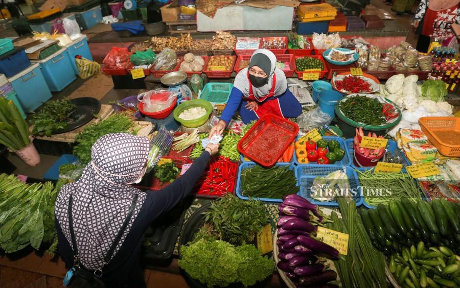 A trader attends to her customer at the Pasar Besar Siti Khadijah in Kota Baru on December 15. - NSTP/NIK ABDULLAH NIK OMAR