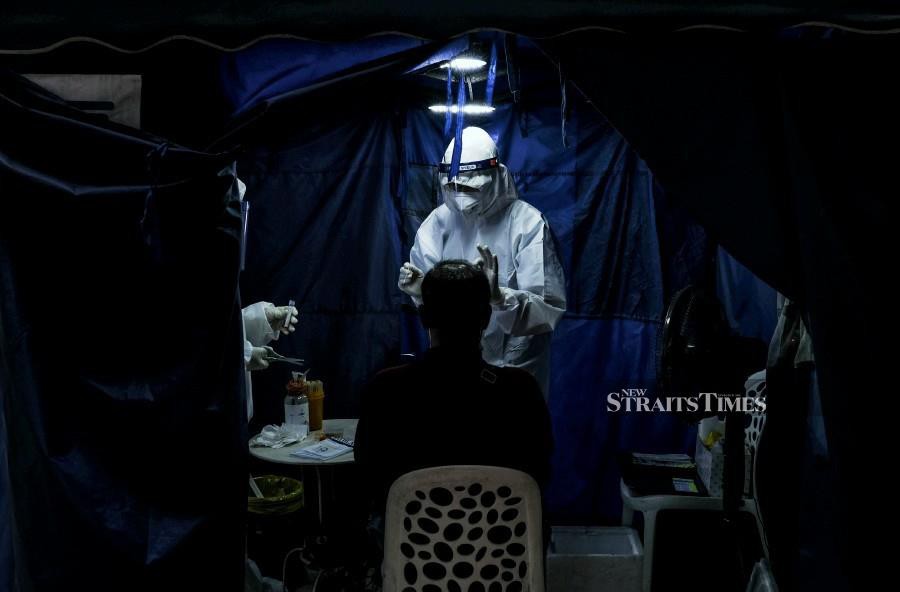 A medical officer attached to a private clinic conducts a Covid-19 screening in Kuala Lumpur. - NSTP/HAZREEN MOHAMAD