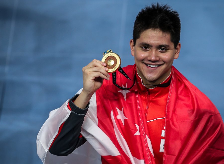 Singapore’s Joseph Schooling pose with his gold medal after winning the 50m butterfly swimming event at national Aquatic Centre in Bukit Jalil. Pic by OSMAN ADNAN.