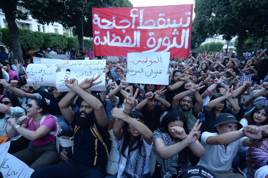 Tunisians block a street during a demonstration in Tunis on May 24, 2024. Several hundred Tunisians marched through the capital chanting "down with the dictatorship" as they protested a spate of arrests under a presidential decree critics say is being used to stifle dissent. -- AFP