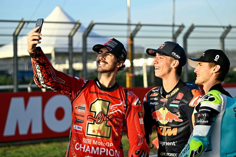 (From L) MotoGP world champion Ducati Italian rider Francesco Bagnaia takes selfie pictures with Moto2 world champion Kalex Spanish rider Pedro Acosta and Moto3 world champion Honda Spanish rider Jaume Masia at the end of the MotoGP Valencia Grand Prix at the Ricardo Tormo racetrack in Cheste, on Nov 26, 2023. -- Pic: AFP