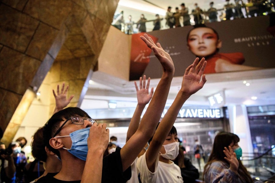 (FILES) This photo taken on May 13, 2020 shows anti-government protesters singing the protest anthem "Glory to Hong Kong" as they gather in a shopping mall in Hong Kong. -- AFP