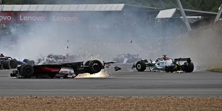  Alfa Romeo's Chinese driver Zhou Guanyu (L) and Mercedes' British driver George Russell (R) skid across the track after a collision at the start of the Formula One British Grand Prix at the Silverstone motor racing circuit in Silverstone. - AFP PIC