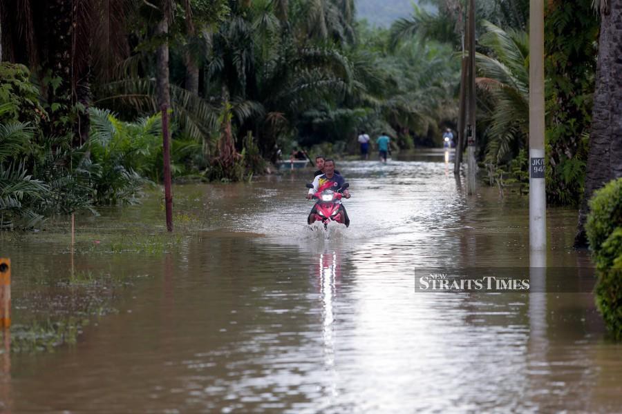 A motorcyclist wades through floodwaters following heavy rain in Jalan Parit Warijo, Sri Medan, Batu Pahat, Johor. -NSTP/ NUR AISYAH MAZALAN