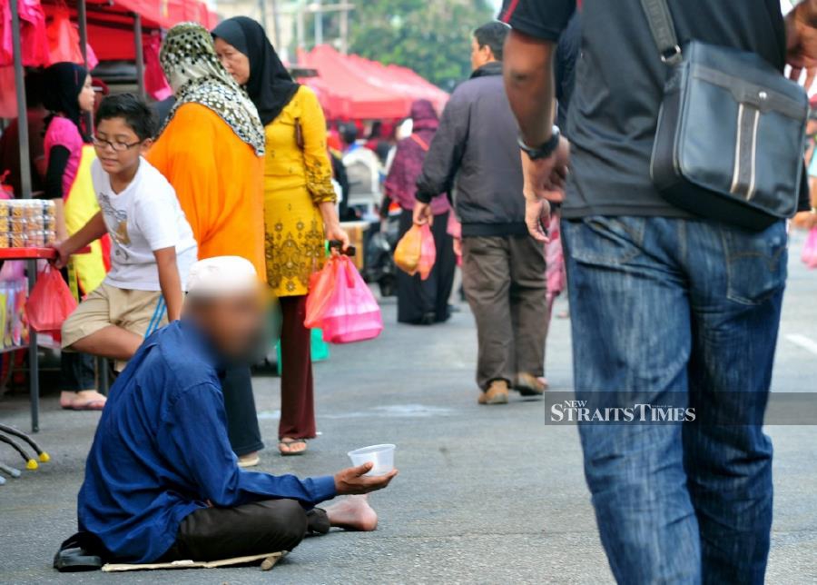 A person is seen seeking donations at Ramadan Bazaar in Kuala Lumpur. - NSTP file pic
