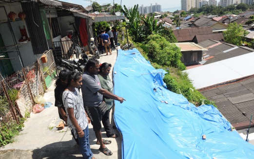 N. Sukumar points at the landslide which occurred at Hong Seng Estate. Residents at the estate have been issued eviction notices and urged to move out immediately. Bernama pix.