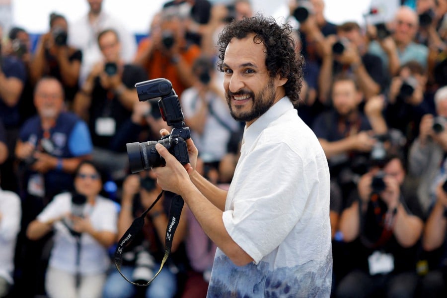 Director Ali Abbasi holds a photo camera during a photocall for the film "The Apprentice" in competition at the 77th Cannes Film Festival in Cannes, France, May 21, 2024. -- REUTERS
