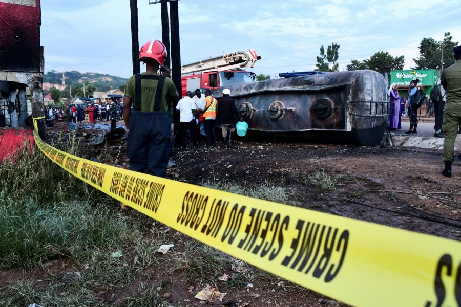 Firefighters and volunteers assess debris at the scene of an explosion, after a fuel tanker rolled and residents started to syphoning fuel, in Kigoogwa suburb, Wakiso district on the outskirts of Kampala, Uganda October 22, 2024. - REUTERS