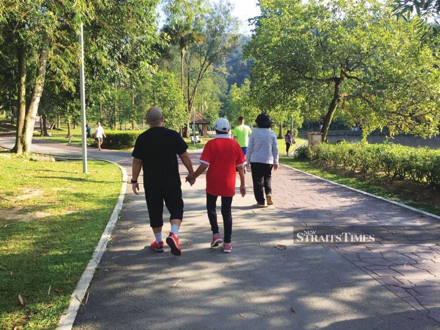 A picture of the writer’s brother accompanying their mother during one of their walks at the park shortly after being diagnosed with cancer. PIC COURTESY OF WRITER