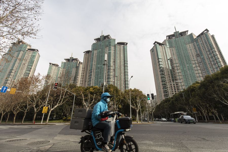A motorist moves past the Riviera Garden residential property, developed by Shimao Group Holdings Ltd., on his scooter in Shanghai, China Photographer: Qilai Shen/Bloomberg